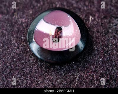 Colored button on a woolen cloth coat. Stock Photo
