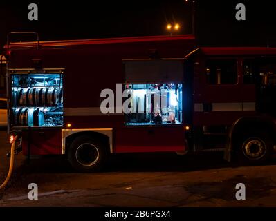 Fire engine during a fire extinguishing at night. Stock Photo