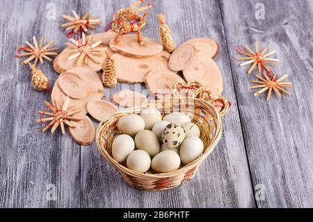 quail easter eggs in a basket, with wooden rustic decorations. on a gray background.Easter concept. Stock Photo