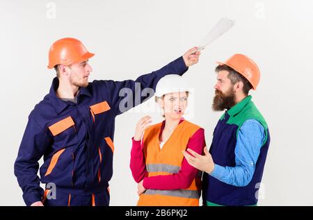 Team of architects concept. Team of architects, engineers discussing work, arguing, isolated white background. Builders and engineer work together. Men in hard hats and uniform and young woman. Stock Photo