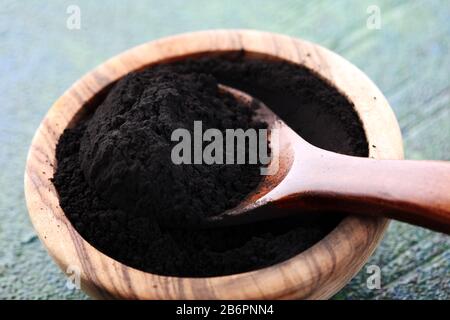 Activated charcoal powder on table for beauty treatment Stock Photo