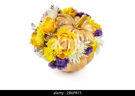 Small golden pumpkin decorated with yellow and blue flowers as a gift on a white background. Stock Photo