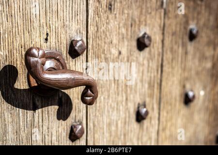 An old rusty metal handle on a wooden door Stock Photo