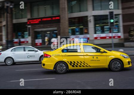 Chongqing, China - August 2019 : Yellow taxi driving on the busy and congested street Stock Photo