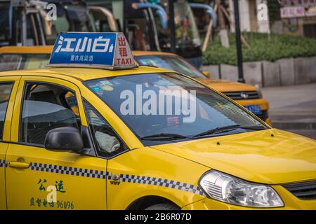Chongqing, China - August 2019 : Yellow taxi driving on the busy and congested street Stock Photo