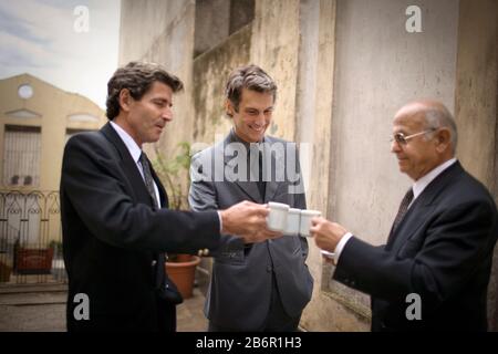View of three men having a conversation over a cup of drink. Stock Photo