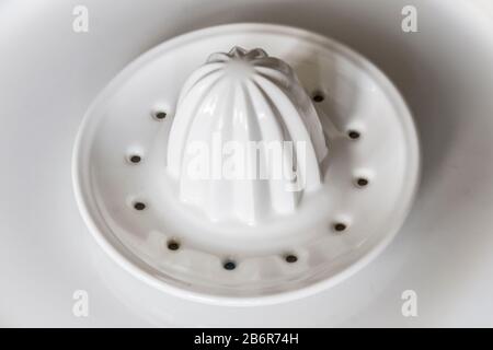 A orange and white ceramic citrus hand press on a plate. Stock Photo