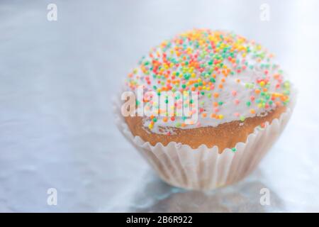 Easter cupcake wrapped in white paper on te table. Stock Photo