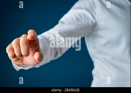Hand of a businessman touching virtual interface screen. Over blue background. Stock Photo