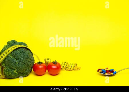 Concept of weight loss, vegetables with measuring tape on a yellow background Stock Photo