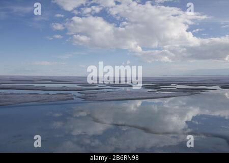 Broken pans of sea ice on ocean coast with blue sky and clouds along the Northwest Passage in June, Cambridge Bay, Nunavut Stock Photo