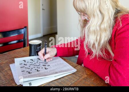 Woman doing crossword puzzle in coffee shop Stock Photo