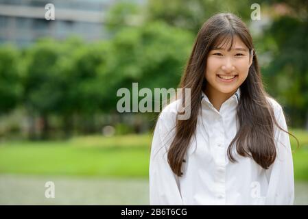 Happy young beautiful Asian teenage girl at the park Stock Photo