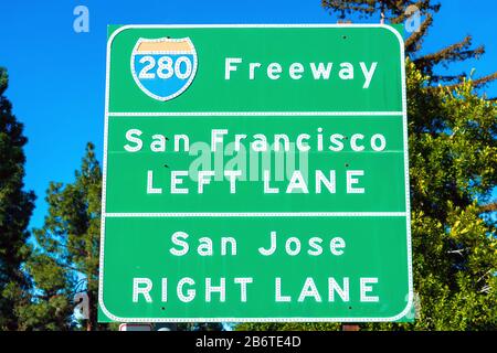 Interstate 280 highway road sign providing information to drivers the directions to San Francisco and San Jose in sunny Silicon Valley. Green trees an Stock Photo
