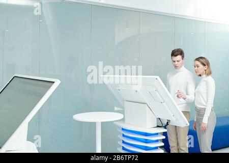 Young colleagues of information center using big interactive display while analyzing data together in office Stock Photo