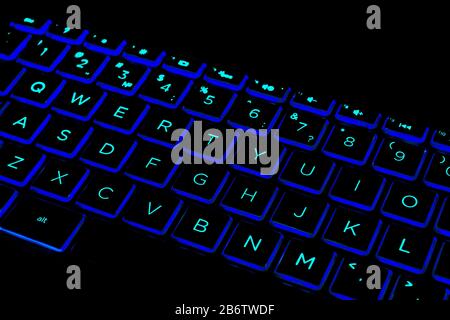 Close up view of a modern laptop computer keyboard keys. Soft lightning in green tones. Pc computer keyboard close up Stock Photo