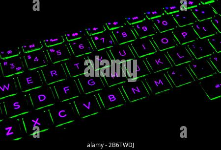 Close up view of a modern laptop computer keyboard keys. Soft lightning in red tones. Pc computer keyboard close up Stock Photo