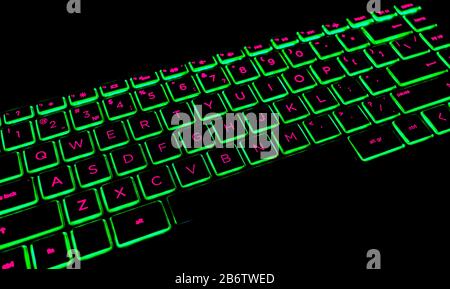 Close up view of a modern laptop computer keyboard keys. Soft lightning in red tones. Pc computer keyboard close up Stock Photo