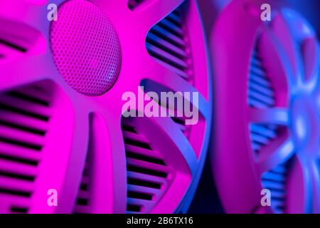 Colorful lights of car stereo and car speakers background.  Car music audio speaker in blue and pink tones. Modern car audio system close up Stock Photo