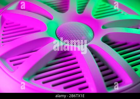 Colorful lights of car stereo and car speakers background.  Car music audio speaker in green and pink tones. Modern car audio system close up Stock Photo