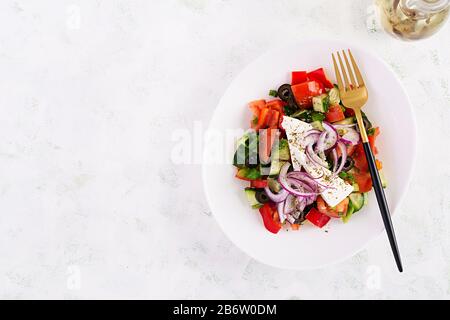 Trendy salad. Greek salad  with fresh vegetables, feta cheese and black olives.  Healthy balanced eating. Top view, overhead, flat lay Stock Photo