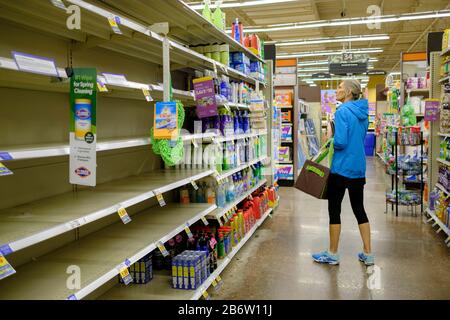 03112020 - Bloomington, Indiana, USA: A woman shops for cleaning supplies at a Kroger in Bloomington, Ind., where shoppers were stocking up on toilet paper, and other items on the day World Health Organization declared Coronavirus to be a pandemic. Toilet paper, wipes, protective breathing masks, and other items are either sold out at local stores, or are in short supply. Stock Photo