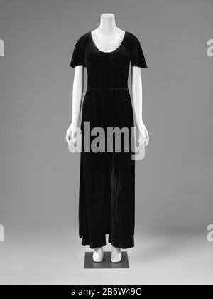 Huispyjama van zwart zijden fluweel, bestaande uit een tuniek (a), een pantalon (b) en een losse, smalle ceintuur (c) Huispyjama van zwart zijden fluweel, bestaande uit een tuniek (a), een pantalon (b) en een losse, smalle ceintuur (c). Model: (a) lage ronde hals, korte vlindermouwen. Recht afhangend; niet getailleerd. Van voren kort met recht schootje, van achter afhangend tot aan de enkels. Gevoerd met zwarte crepe de chine; Smal ceintuurtje van zijden fluweel (c); (b) zonder tailleband, met wijde pijpen. Gevoerd met zwarte crepe de chine. Manufacturer : modehuis: Denise Vandervelde-Borgeaud Stock Photo