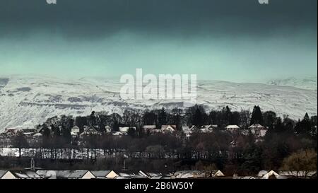 Glasgow, Scotland, UK, 12th March, 2020: UK Weather: Overnight snow was highlighted on the Campsie Fell  hills in the north west of the city over the suburb of Bearsden. Copywrite Gerard Ferry/ Alamy Live News Stock Photo