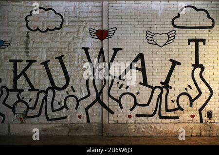 The name Kuwait painted in graffiti on white brick wall Stock Photo