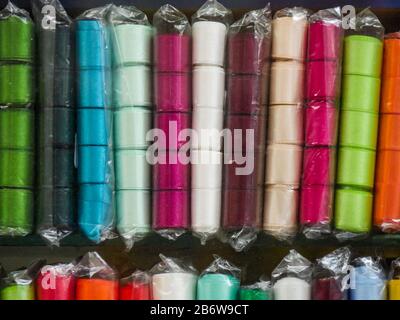 Multi-colored ribbon on the shelf. Textile shop. Sewing goods store. Bright handmade concept. Textile industry. Stock Photo