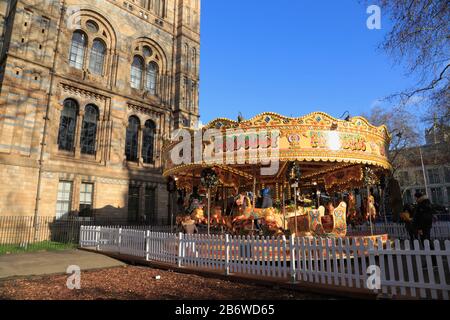 A carousel, as part of the Christmas holiday activities, outside the Natural History Museum in South Kensington, London, UK. Stock Photo