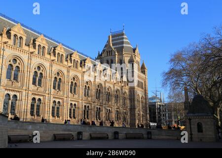 People walk towards the entrance of the Natural History Museum that was built in terracotta and resembles a cathedral, in Kensington, London, UK. Stock Photo