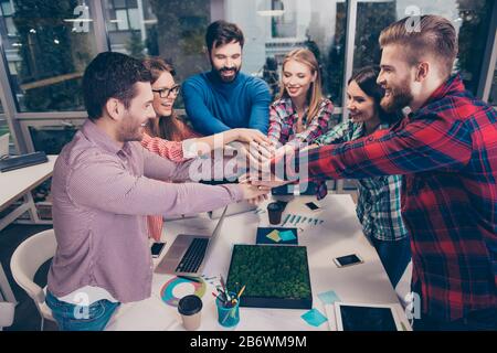 Happy young freelancers putting their fist on top of each other. Stock Photo