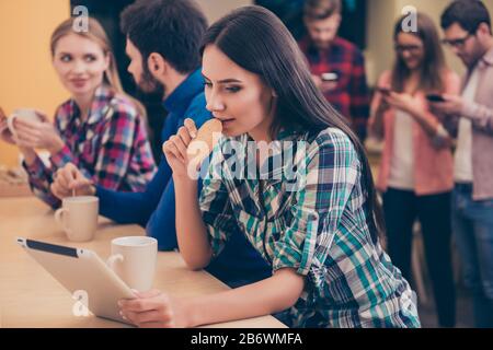 Happy woman eating cookie while her collegues working on project. Stock Photo