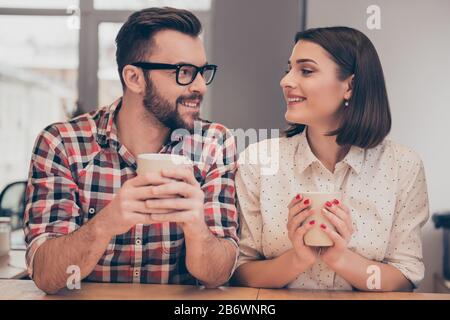 Portrait of young smiling workers having lunch and drinking coffee. Stock Photo
