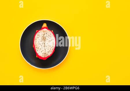 Pitaya. The close-up of ripe dragon fruit on plate on yellow background. Stock Photo
