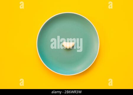 Garlic with a single clove peeled on blue plate. Stock Photo