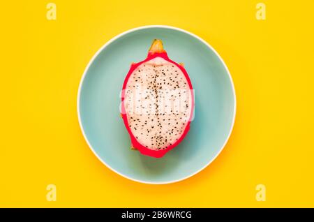 Pitaya. The close-up of ripe dragon fruit on plate on yellow background. Stock Photo