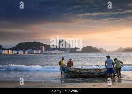 Local fishermen on Copacabana beach at dawn Stock Photo