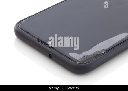 Damaged smartphone protective glass. With air under the glass. On the top left edge. Ruptured phone surface glass. Isolated on white background with s Stock Photo