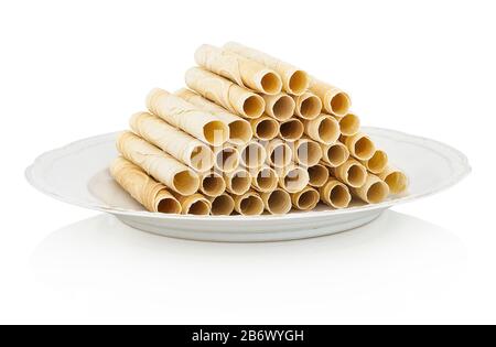 Christmas tube-shaped wafers on ceramic plate. In slovak called: 'Trubičky'. Isolated on white background with shadow reflection. With clipping path. Stock Photo