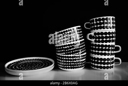 A set of dishes on black background. Mugs, bowls and plates on white table. Stock Photo