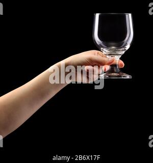 Woman hand holding empty beer glass isolated on black. Stock Photo