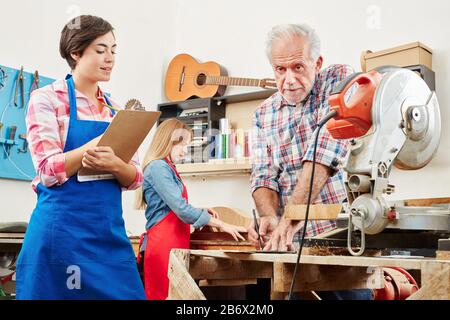 Woman is doing apprenticeship in guitar maker and making notes on a clipboard Stock Photo