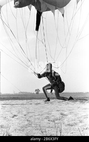 30 November 1984, Saxony, Eilenburg: A skydiver lands in the GST training centre 'Rote Jahne' near Eilenburg in the 1980s. Exact date of recording not known. Photo: Volkmar Heinz/dpa-Zentralbild/ZB Stock Photo