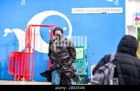 Brighton UK 12th March 2020 - A man wearing a face mask walks through Brighton today as the British government is expected to bring in the delay phase to help combat the Coronavirus COVID-19 pandemic  . Credit: Simon Dack / Alamy Live News Stock Photo