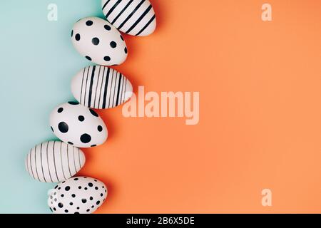 Easter eggs dotted on multicolored background. Festive concept. Flat lay style Stock Photo