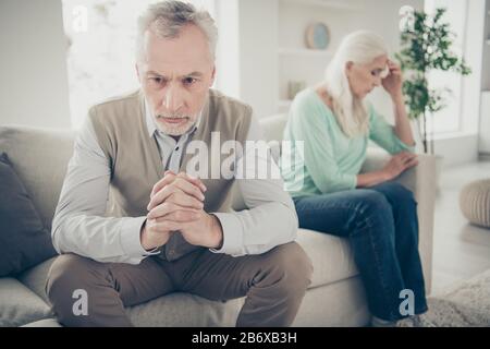 Closeup photo of thinking pondering having plan granddad sitting on divan with his hands crossed Stock Photo