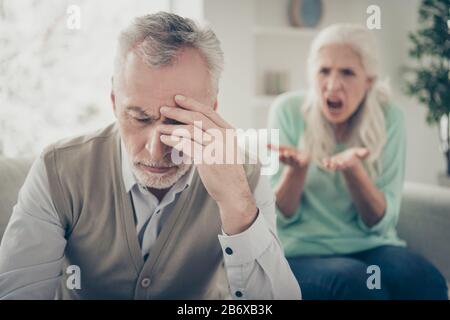 Close up photo of upset sad tired exhausted man touching head having headache from the voice of his aggressive wife Stock Photo