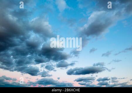 Skyscape.  Clouds in blue sky near sunset. Stock Photo